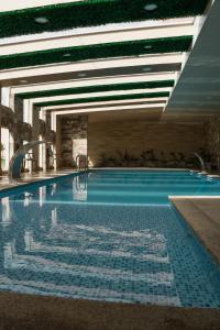 a large swimming pool with blue tiles on the floor at Hotel Spa CASA REAL in Riobamba