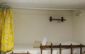 a room with two bunk beds and a cross on the wall at Artetude Hostel Cultural in Barra de Guaratiba