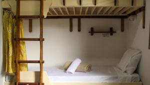 a bedroom with two bunk beds and a ladder at Artetude Hostel Cultural in Barra de Guaratiba