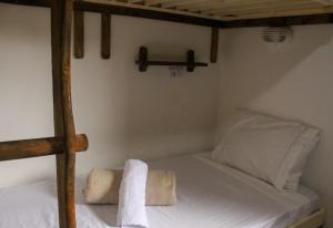 a bedroom with a bunk bed with two towels on it at Artetude Hostel Cultural in Barra de Guaratiba