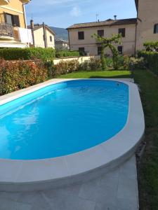 a large blue swimming pool in a yard at House Barbanera in Spello