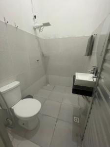 a bathroom with a toilet and a sink at Suítes JK in Paragominas