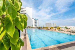 a pool at a hotel with buildings in the background at Magica Cartagena Suite in Cartagena de Indias