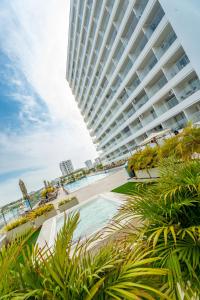 a large building with a swimming pool and a beach at Magica Cartagena Suite in Cartagena de Indias