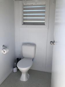 a bathroom with a white toilet and a window at The Hideaway in Emu Park