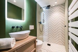 ein Badezimmer mit weißem Waschbecken und Dusche in der Unterkunft Green Kööv in Wenningstedt-Braderup