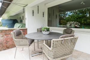 ein Terrassentisch und Stühle mit einer Topfpflanze in der Unterkunft Green Kööv in Wenningstedt-Braderup