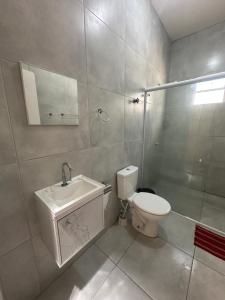 a bathroom with a sink and a toilet and a mirror at Casa Amarela no Fortim in Fortim