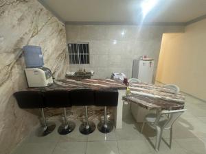 a kitchen with a counter with stools and a coffee maker at Casa Amarela no Fortim in Fortim +9 photos