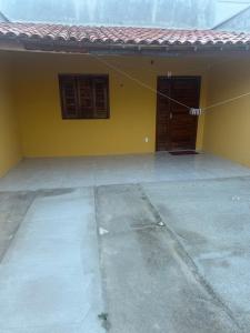 a yellow house with two windows and a door at Casa Amarela no Fortim in Fortim