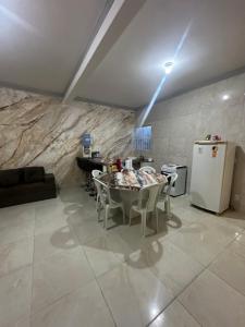 a living room with a table and a refrigerator at Casa Amarela no Fortim in Fortim