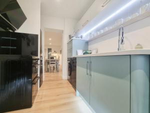 a kitchen with white cabinets and a black refrigerator at Mac Shack Cottage - Uk32376 in Ashen