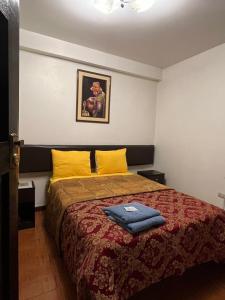 a bedroom with a large bed with yellow pillows at Viajeros Centro in Machu Picchu