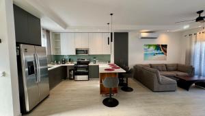 eine Küche und ein Wohnzimmer mit Sofa und Tisch in der Unterkunft Casa de Lemon in Coco