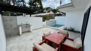 eine Terrasse mit Tisch, Stühlen und einem Waschbecken in der Unterkunft Casa de Lemon in Coco
