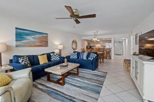 a living room with blue couches and a table at Perdido Quay 501 by Youngs Suncoast in Orange Beach