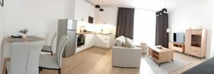 a white living room with a table and a kitchen at Apartament 37 in Sosnowiec