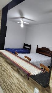a bedroom with two beds and a ceiling fan at Calmaria in Arraial do Cabo
