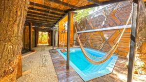 a hammock in a tree house with a pool at Mr Pakal Tulum in Tulum