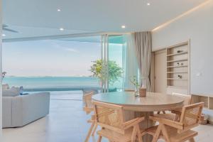a living room with a table and a view of the ocean at Replay Pool Villa in Bangrak Beach