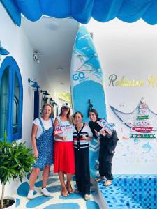 a group of women standing in front of a surfboard at Robinson Homestay - Cù Lao Mái Nhà in Tuy An