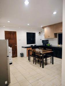 a kitchen with a table and chairs in it at Pasadena Home in Tawau