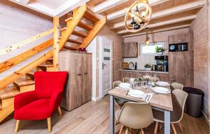 a dining room with a red chair and a table at Stunning Home In Sarbinowo in Sarbinowo