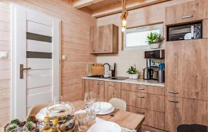 a dining room with a table and a kitchen at Stunning Home In Sarbinowo in Sarbinowo