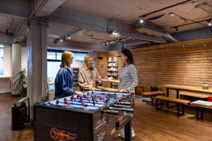 a group of people standing around a foosball table at MEANDER Taipei in Taipei