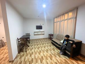 a young boy sitting on a couch in a living room at Las Lomas Hotel in Caraz