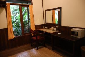 a desk with a mirror and a chair in a room at Rimba Orangutan Ecolodge in Kampungcina