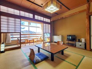a living room with a table and a living room with a tv at 偕楽園 in Shirasaka