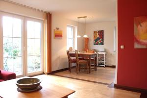 a living room with a table and a dining room at Gerdemann in Timmendorf +5 photos