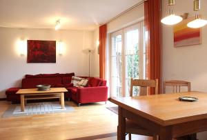a living room with a red couch and a table at Gerdemann in Timmendorf