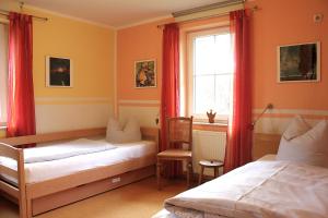 a bedroom with two beds and a window with red curtains at Gerdemann in Timmendorf