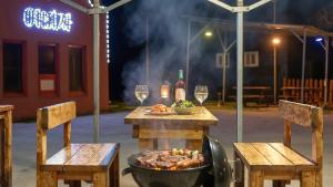 a table with two chairs and a bowl of food and wine glasses at Chuncheon Vishop Pension in Chuncheon +1 photo