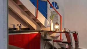 a kitchen with red cabinets and a counter with stools at Chuncheon Vishop Pension in Chuncheon