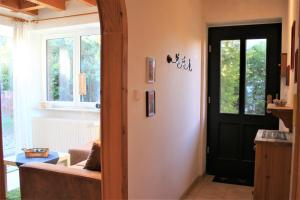 a living room with a black door and a couch at Lütt Eddy in Kaltenhof +6 photos