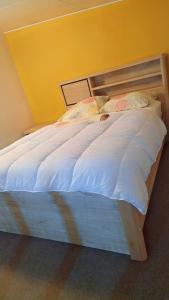 a bed with a wooden frame in a bedroom at Emma modern suite in Kourou