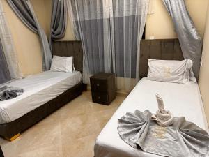 a bedroom with two beds and a night stand at CASA Hamburg NADOR AL JADID in Nador