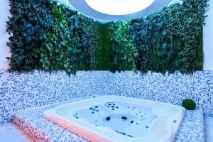 a jacuzzi tub in a bathroom with green plants at Hotel Wellness & Spa Nowy Dwór in Rzeszów