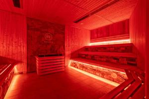 a red room with red lighting and benches in it at Hotel Wellness & Spa Nowy Dwór in Rzeszów
