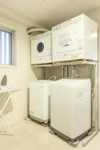 a pile of appliances sitting on a shelf in a room at Address Nozawa in Nozawa Onsen