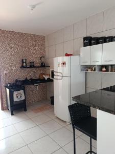 a kitchen with a white refrigerator and a stove at Hostel de clecia in Extremóz