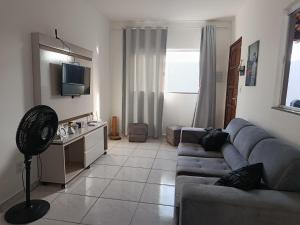 a living room with a couch and a table with a fan at Hostel de clecia in Extremóz