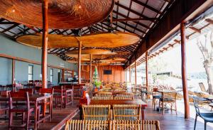 a restaurant with wooden tables and chairs and a lot of windows at Onederz Koh Rong Sanloem in Koh Rong Sanloem