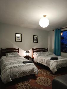 a bedroom with two beds and a lamp and a couch at El Caracol in Popayan