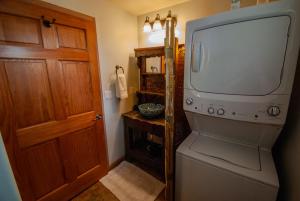 a bathroom with a tv and a washer and dryer at Santuario Grande in Los Ranchos de Albuquerque +84 photos