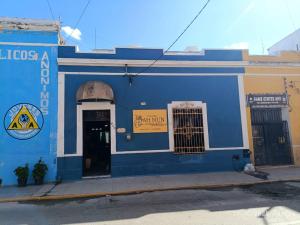 a blue building with a sign on the side of it at Hotel y Hostal AH MUN in Mérida