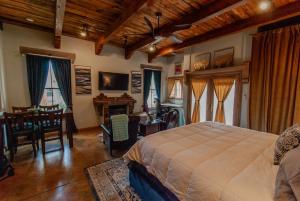 a bedroom with a bed and a table and a desk at Santuario Grande in Los Ranchos de Albuquerque